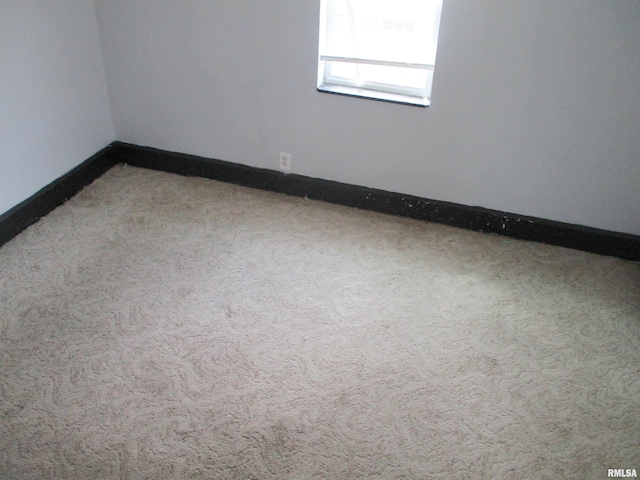 unfurnished room with baseboards and carpet flooring