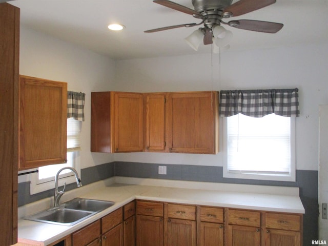 kitchen with light countertops, plenty of natural light, brown cabinetry, and a sink