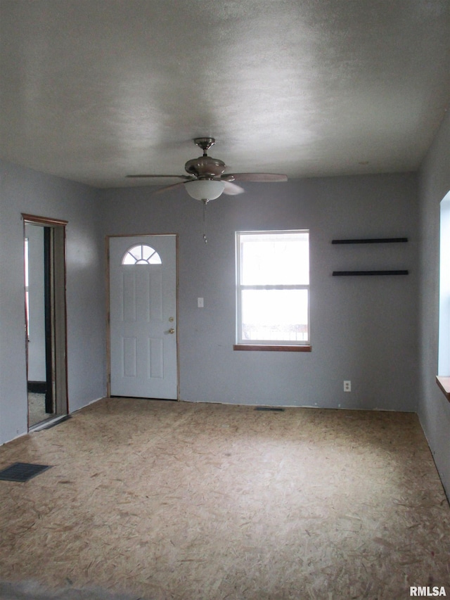 entryway featuring a ceiling fan, visible vents, and carpet