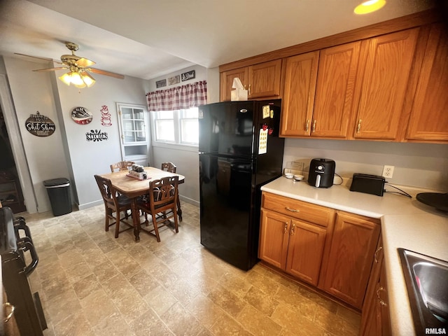 1837 Baird Ave, Galesburg, IL 61401 - kitchen featuring light countertops, a sink, freestanding refrigerator, brown cabinetry, and ceiling fan