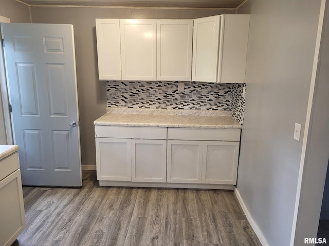 148 Robinson Ct, Canton, IL 61520 - kitchen with decorative backsplash, wood finished floors, baseboards, and white cabinetry