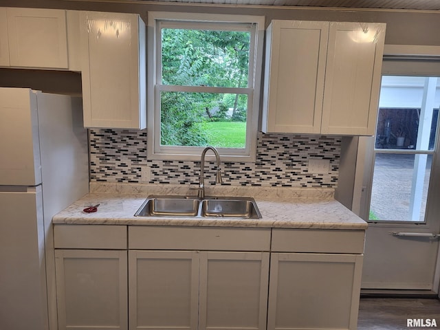 148 Robinson Ct, Canton, IL 61520 - kitchen with freestanding refrigerator, a sink, decorative backsplash, and white cabinetry