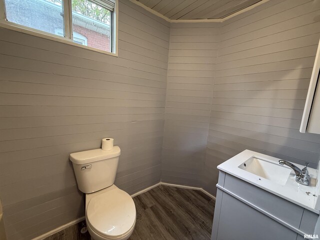 bathroom featuring wood finished floors, toilet, vanity, wooden ceiling, and wooden walls