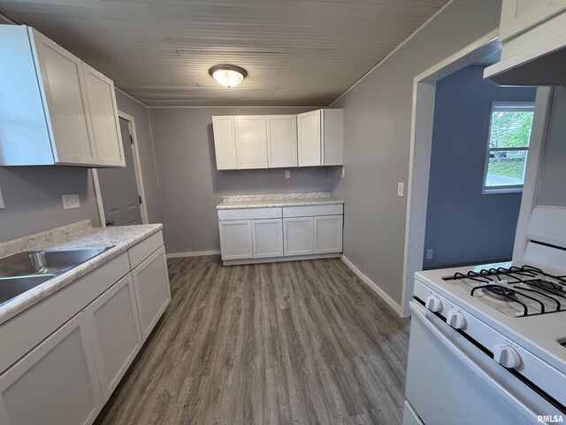 kitchen featuring gas range gas stove, wood finished floors, white cabinetry, under cabinet range hood, and wooden ceiling