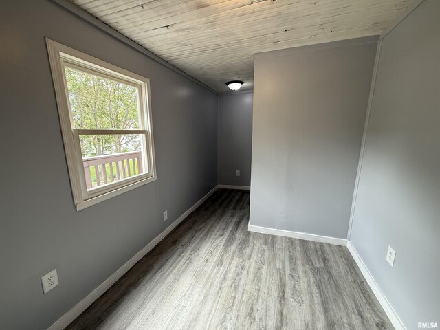unfurnished room with wood finished floors, baseboards, and wood ceiling