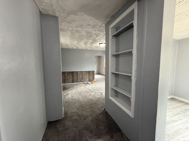 hallway with carpet and baseboards