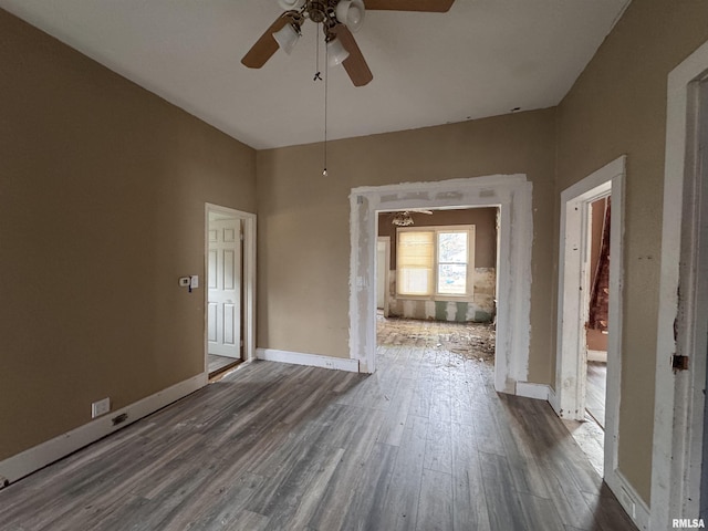 unfurnished room featuring baseboards, a ceiling fan, and wood finished floors