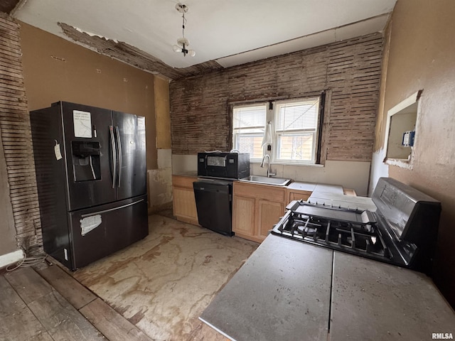 kitchen featuring black appliances, light brown cabinetry, a sink, and light countertops