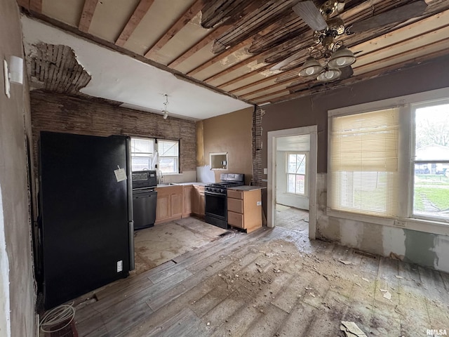 kitchen with range with gas cooktop, freestanding refrigerator, a wealth of natural light, and light brown cabinets