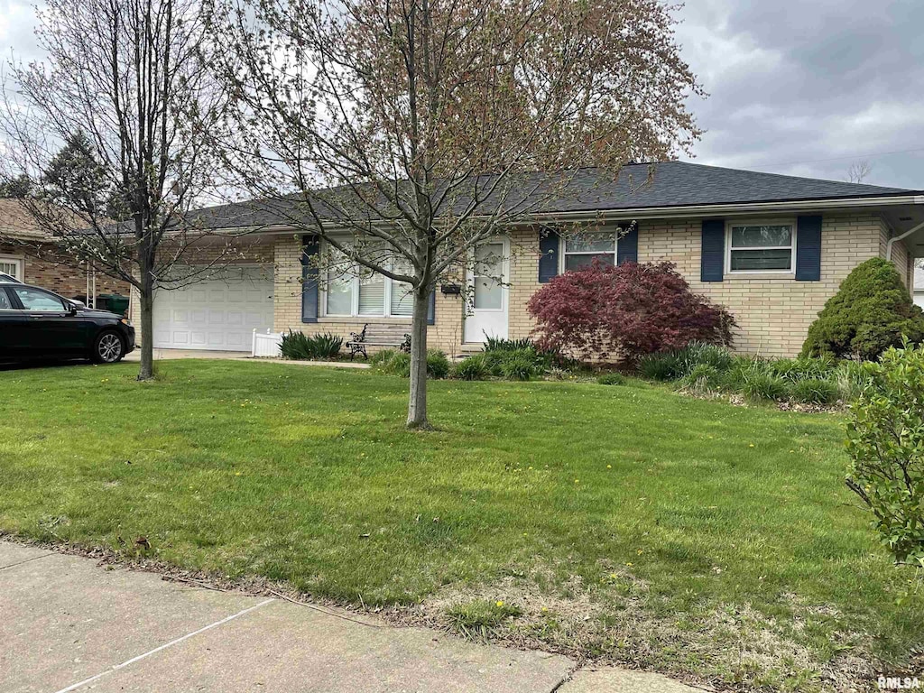 ranch-style home with a front lawn, brick siding, and a garage