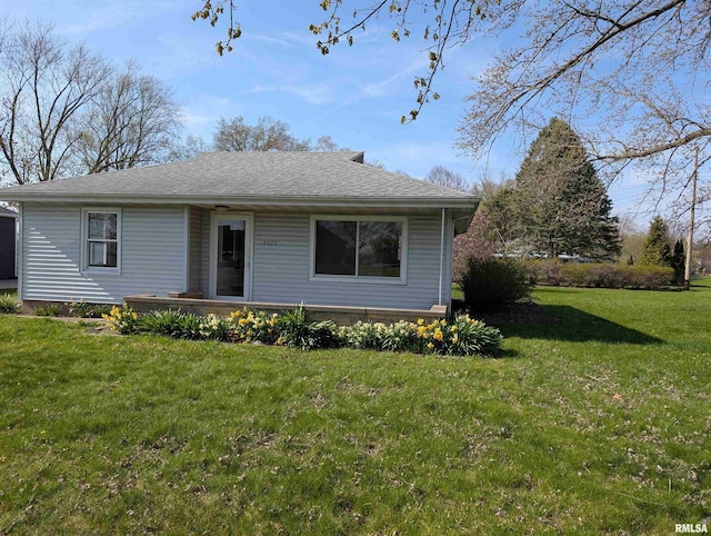 view of front of house featuring roof with shingles and a front yard