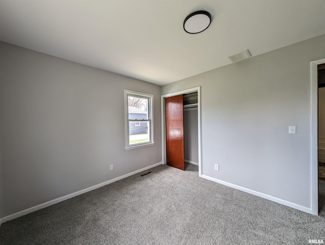 unfurnished bedroom featuring baseboards, carpet flooring, visible vents, and a closet