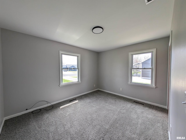 spare room with visible vents, baseboards, and carpet
