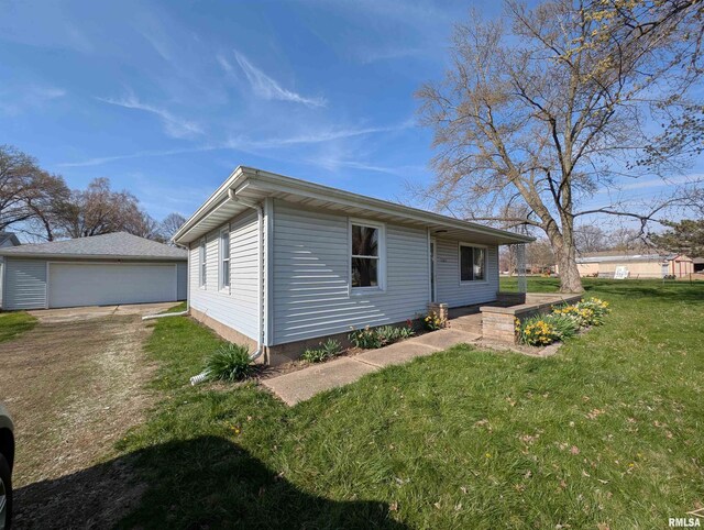 view of side of home featuring a lawn, an outdoor structure, and a detached garage