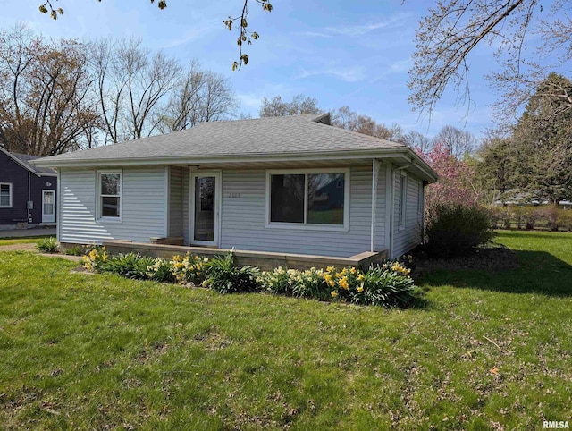 view of front of property featuring roof with shingles and a front yard