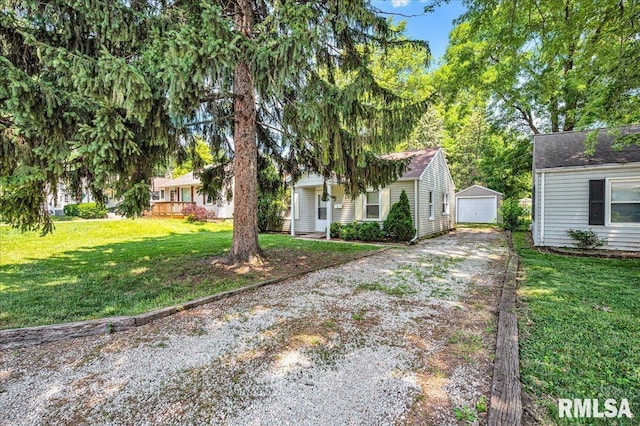 301 E Ellington Dr, Peoria, IL 61603 - view of front of house featuring driveway, a detached garage, a front lawn, and an outbuilding