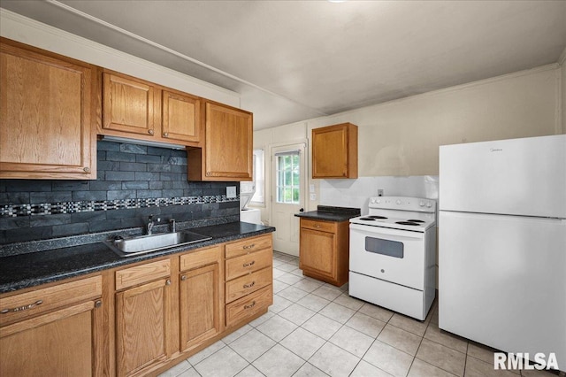 301 E Ellington Dr, Peoria, IL 61603 - kitchen featuring white appliances, light tile patterned flooring, dark countertops, tasteful backsplash, and brown cabinets