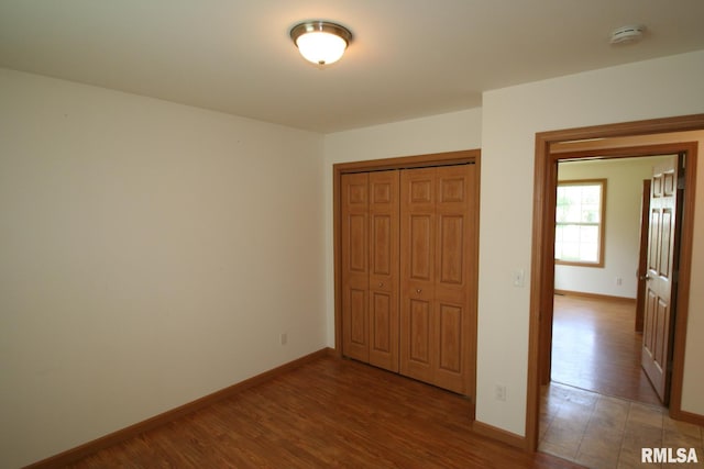 406 N Minier Ave, Minier, IL 61759 - unfurnished bedroom featuring baseboards, wood finished floors, and a closet