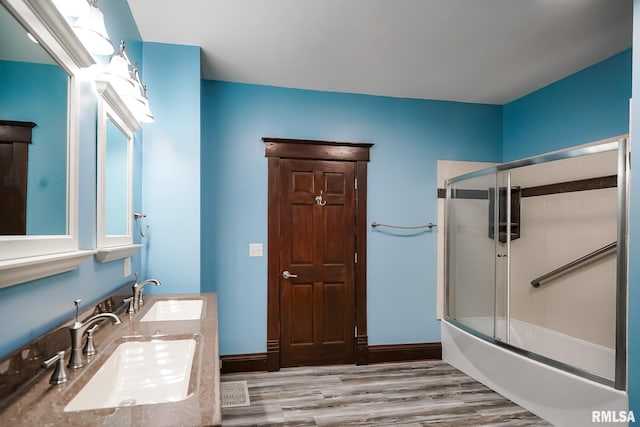 238 E Prospect St, Galesburg, IL 61401 - bathroom featuring wood finished floors, a sink, bath / shower combo with glass door, and double vanity