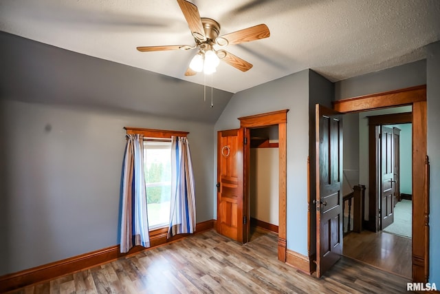 238 E Prospect St, Galesburg, IL 61401 - unfurnished bedroom with vaulted ceiling, ceiling fan, baseboards, and wood finished floors