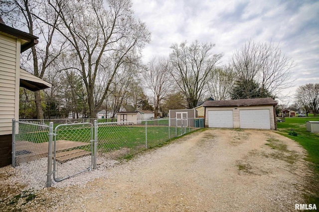 238 E Prospect St, Galesburg, IL 61401 - view of yard featuring fence, driveway, an outdoor structure, and a detached garage