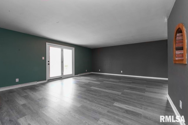 empty room with baseboards and wood finished floors