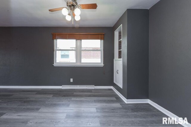 spare room featuring ceiling fan, baseboards, and wood finished floors
