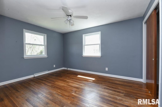unfurnished bedroom featuring dark wood finished floors, a closet, and baseboards
