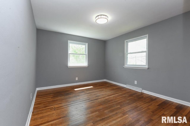 unfurnished room featuring baseboards, visible vents, and dark wood-type flooring