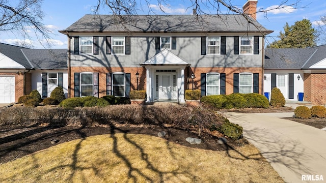 view of front of house with a chimney and brick siding