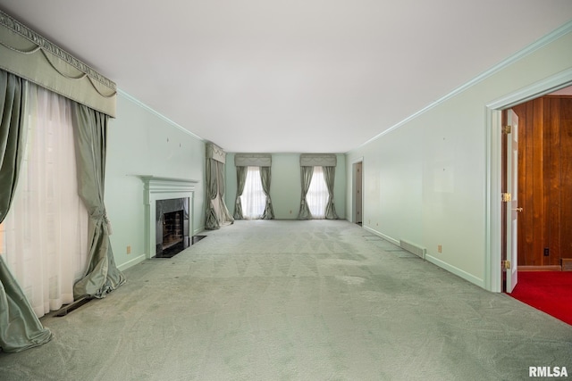 unfurnished living room with visible vents, ornamental molding, baseboards, a fireplace, and carpet flooring
