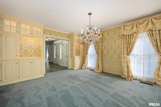 unfurnished dining area featuring wallpapered walls, visible vents, a chandelier, and a decorative wall