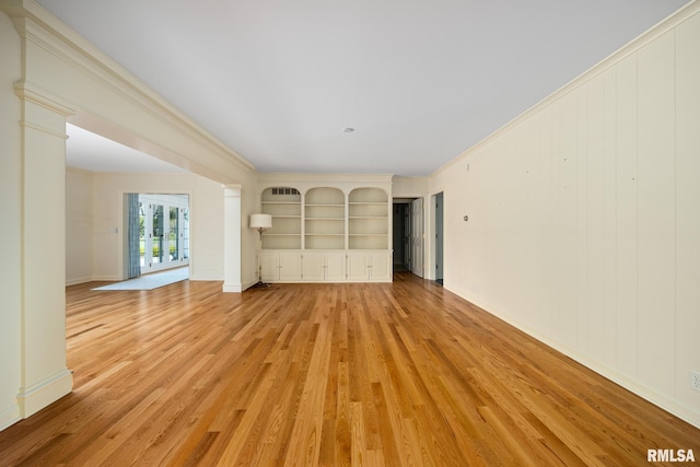 unfurnished living room with decorative columns, baseboards, built in shelves, light wood-style floors, and crown molding