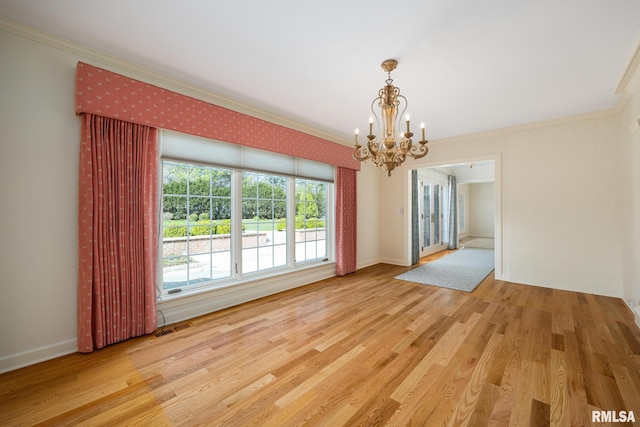 unfurnished dining area with baseboards, wood finished floors, an inviting chandelier, and crown molding