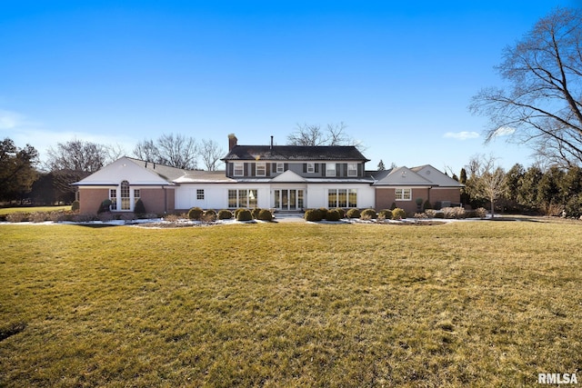 rear view of property with a yard and a chimney