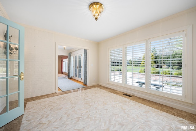 unfurnished room with visible vents, ornamental molding, and french doors