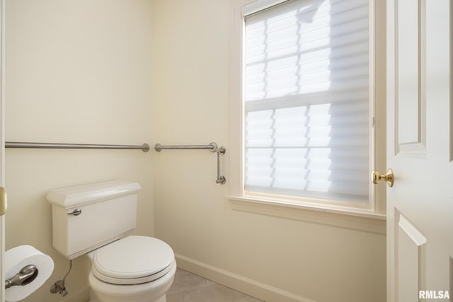bathroom featuring toilet, tile patterned floors, and baseboards