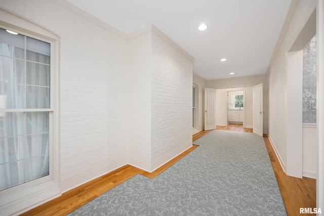 hallway with recessed lighting, wood finished floors, crown molding, and baseboards