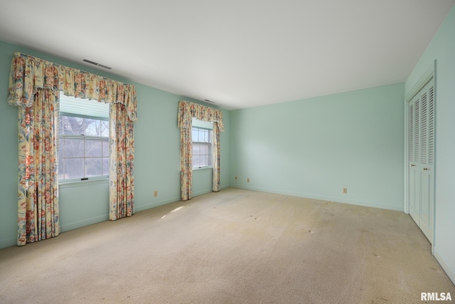 unfurnished bedroom with carpet floors, a closet, visible vents, and baseboards