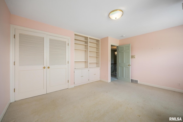 unfurnished bedroom with visible vents, light carpet, and baseboards