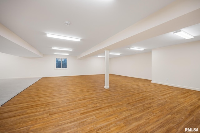 below grade area featuring baseboards and wood finished floors