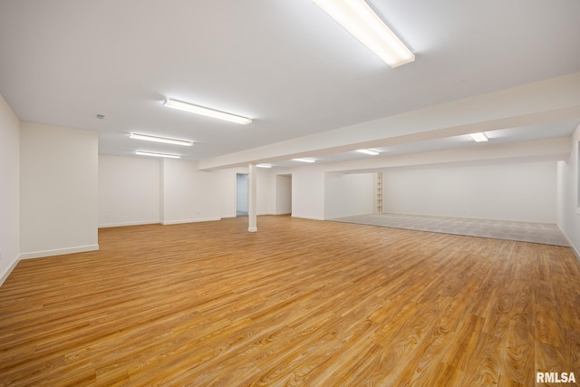 finished basement featuring light wood finished floors and baseboards