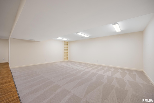 bonus room with built in shelves, baseboards, and light carpet