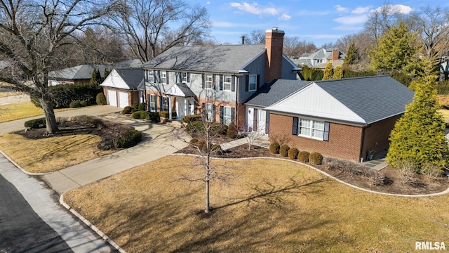 view of front facade featuring a chimney, a residential view, driveway, brick siding, and a garage