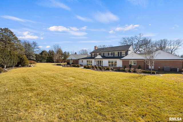 back of property with cooling unit and a yard
