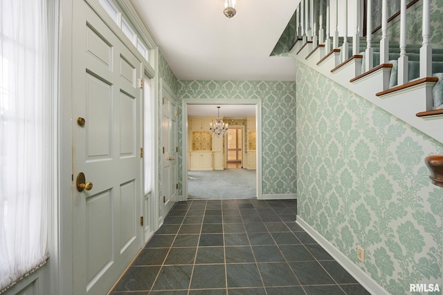interior space with wallpapered walls, baseboards, a wealth of natural light, and a notable chandelier