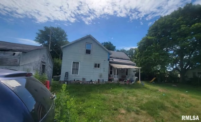 rear view of property featuring a lawn and a playground
