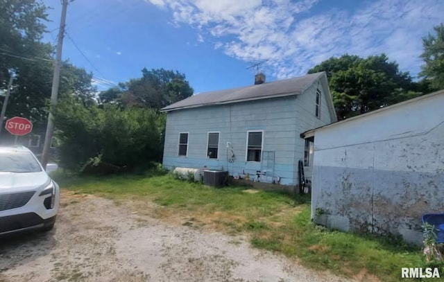 view of property exterior featuring a chimney and central AC