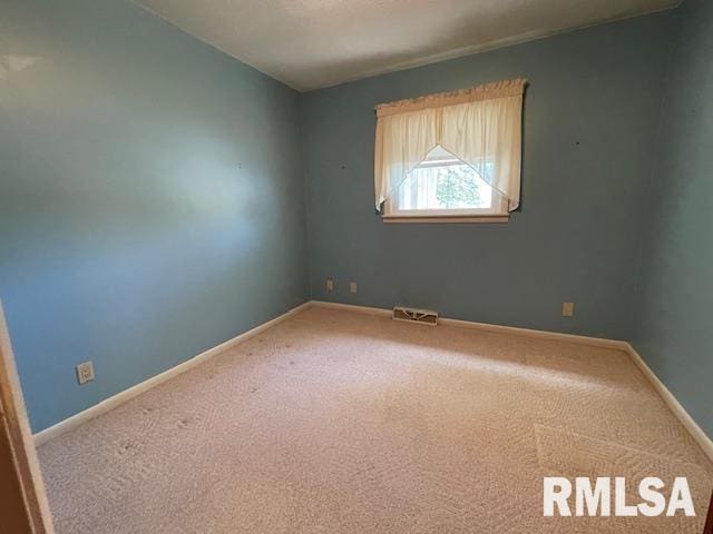 empty room with baseboards, visible vents, and carpet floors