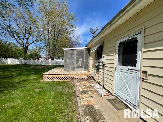 view of yard with a sunroom and fence